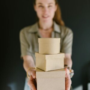 Blurred woman holding a stack of cardboard boxes, ideal for concepts of e-commerce and small business.