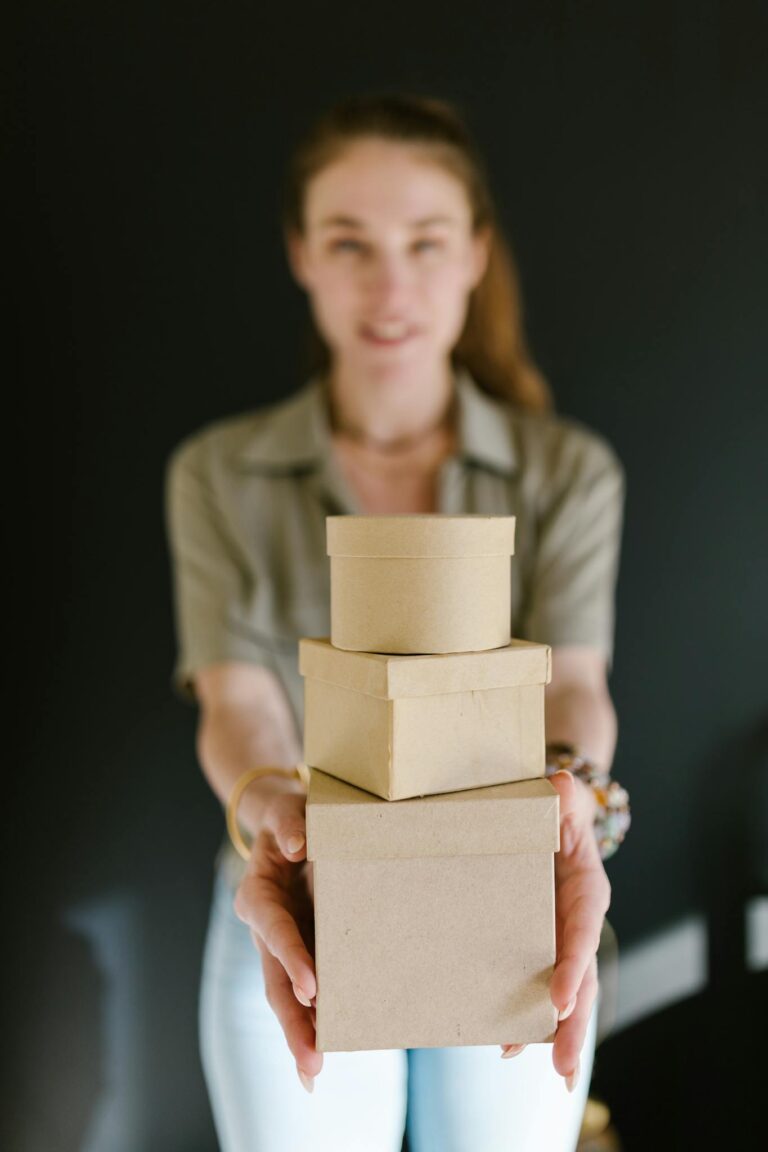 Blurred woman holding a stack of cardboard boxes, ideal for concepts of e-commerce and small business.