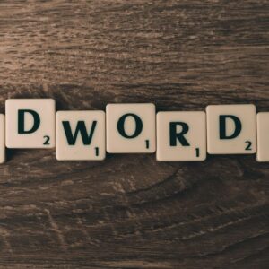 Scrabble tiles spelling 'AdWords' on a wooden surface, symbolizing digital marketing concepts.